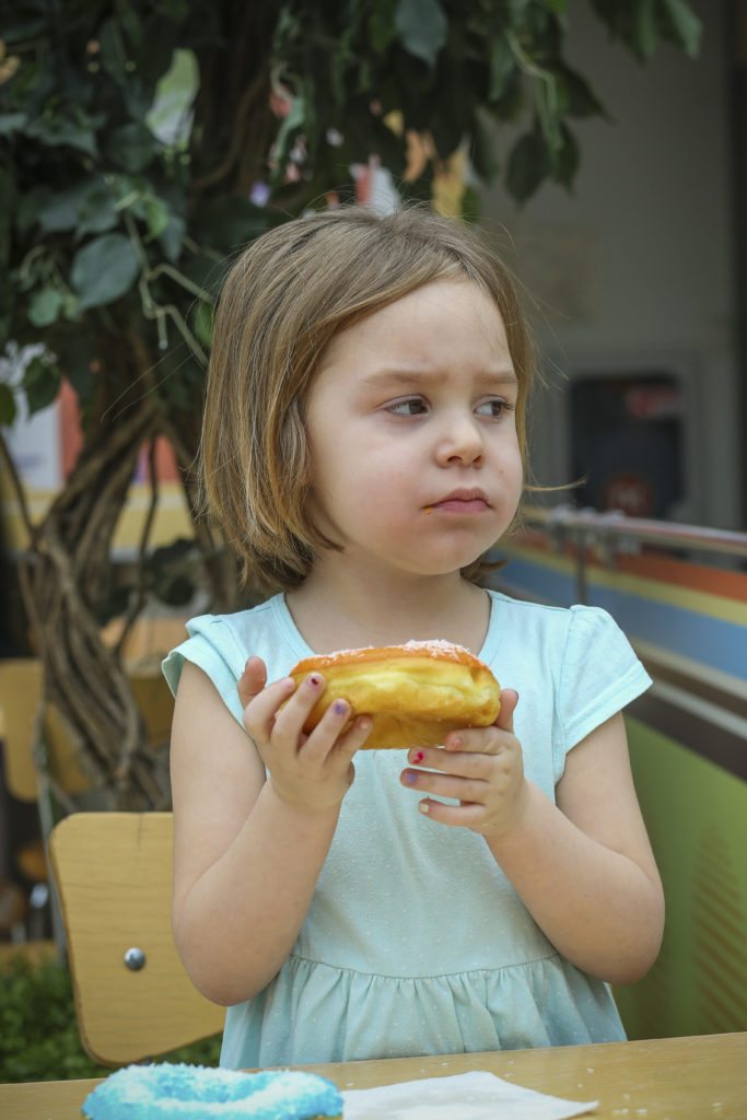 Concerned child is sick from donuts fed by parents